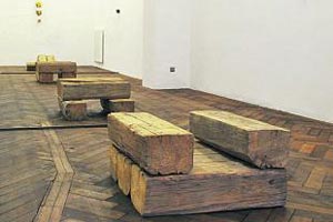 Artikelbild: Rohe Holzblock-Objekte von Richard Nonas kontrastieren mit dem Parkettboden der Galerie. - Foto: Galerie Winter 